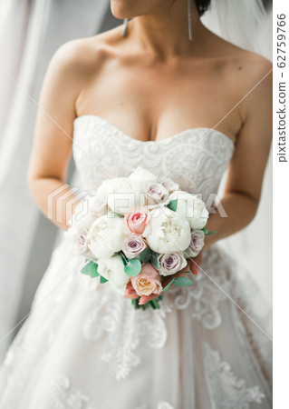 Bride holding big and beautiful wedding bouquet with flowers Bride holding big and beautiful wedding bouquet with flowers 62759766