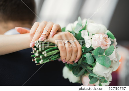 Bride holding big and beautiful wedding bouquet with flowers Bride holding big and beautiful wedding bouquet with flowers 62759767