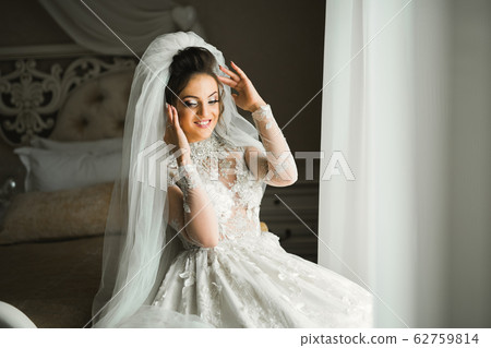 Portrait of beautiful bride with fashion veil at wedding morning Portrait of beautiful bride with fashion veil at wedding morning 62759814