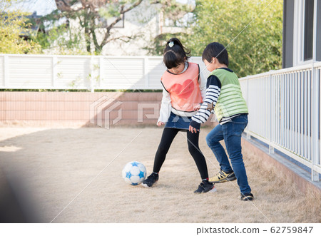 男孩和女孩在花園裡練習足球 男孩和女孩在花園裡練習足球 62759847