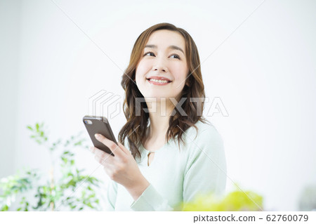 A young woman operating a smartphone 62760079