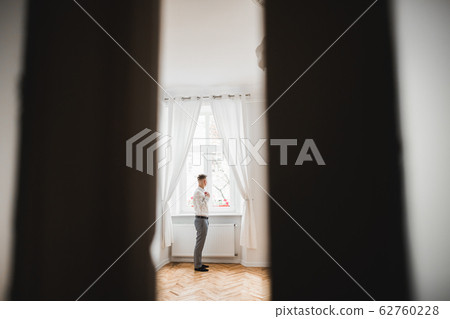 Young handsome man relaxing at his apartment in a hotel after business meeting Young handsome man relaxing at his apartment in a hotel after business meeting 62760228