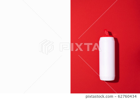 White plastic bottle of detergent powder or cleaning agent on red background. Copy space. Top view. Flat lay. Household chemicals concept 62760434