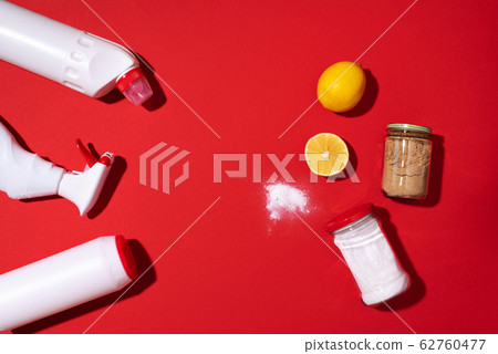 Baking soda, lemon and mustard powder against household chemicals products over red background. Top view. Copy space. Flat lay. Effective and safe house cleaning 62760477