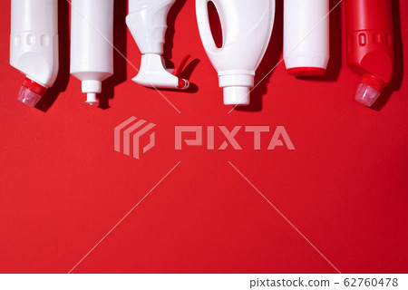 Detergent bottles and chemical cleaning supplies on red background. Top view. Copy space. Flat lay. Detergent bottles and chemical cleaning supplies on red background. Top view. Copy space. Flat lay. 62760478