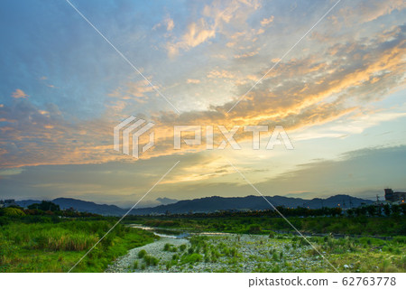 太陽沿著天際線升起，美麗的天空在空中。 62763778