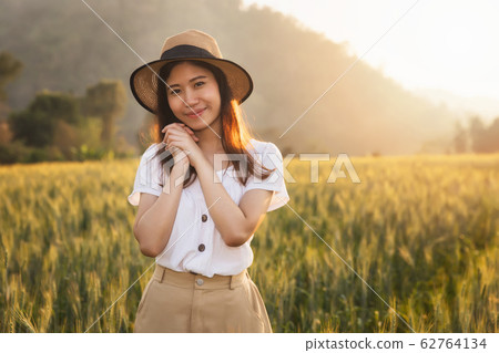 Beautiful and happy asian woman enjoying life in barley field 62764134