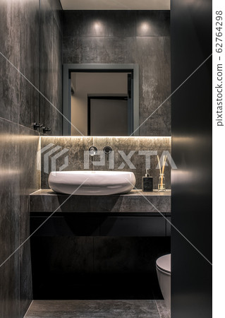 Trendy modern restroom with tiled dark walls Trendy modern restroom with tiled dark walls 62764298