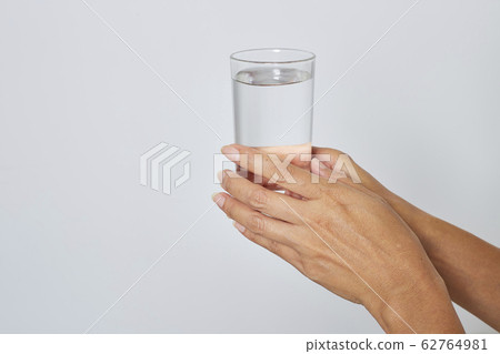 female hand holding a glass of water female hand holding a glass of water 62764981