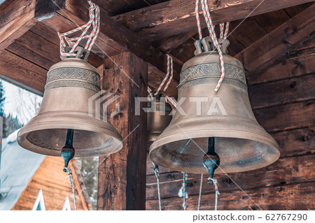 Bronze bells of an old wooden chapel. Old bronze bells in a village church 62767290