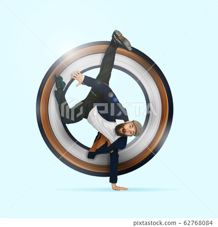 Businessman having fun dancing break dance on blue background at work Businessman having fun dancing break dance on blue background at work 62768084
