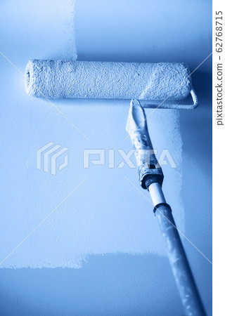 Painting wall with paint roller in monochrome color. Appartment renovation, repair, building and home concept. Trendy blue and calm color. Copy space, banner. Tools for painting walls. Painting wall with paint roller in monochrome color. Appartment renovation, repair, building and home concept. Trendy blue and calm color. Copy space, banner. Tools for painting walls. 62768715
