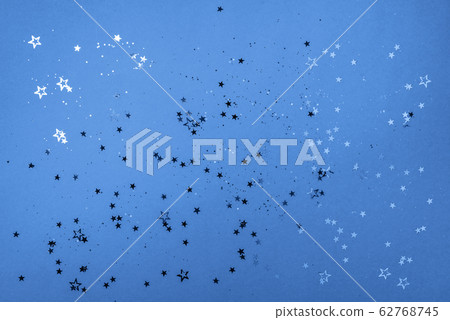 Star sparkles on classic blue background. Christmas and New year concept. Festive color backdrop with copy space 62768745