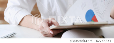 Female hands hold clipboard pad with financial statistics Female hands hold clipboard pad with financial statistics 62768834