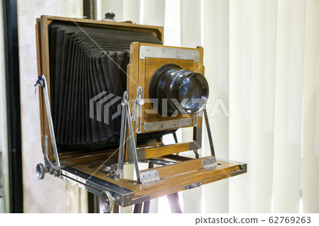 Very old rustic vintage large format camera as decoration in a room again white background. Side view. Very old rustic vintage large format camera as decoration in a room again white background. Side view. 62769263