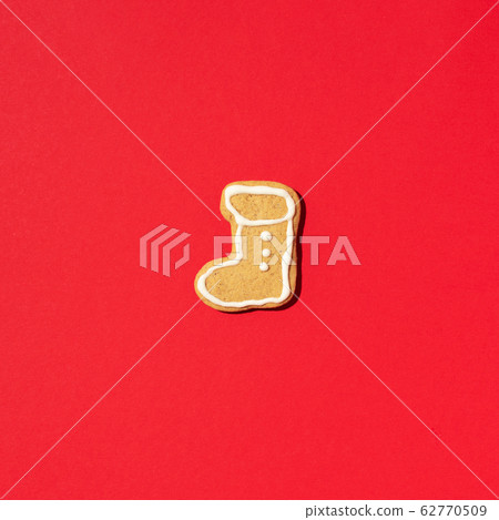Festive handmade cookies on red background. Gingerbread boot shapes. New year and Christmas concept Festive handmade cookies on red background. Gingerbread boot shapes. New year and Christmas concept 62770509