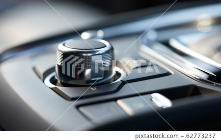 Closeup of a modern car interior with media and navigation control buttons 62773237