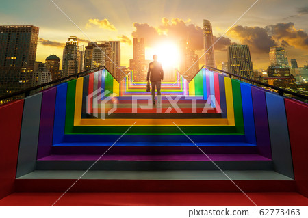 Businessman climbing on colorful stair to modern city, ambitions concept . 62773463
