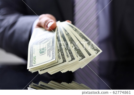 Man hold in arm pack of hundred dollar bills Man hold in arm pack of hundred dollar bills 62774861