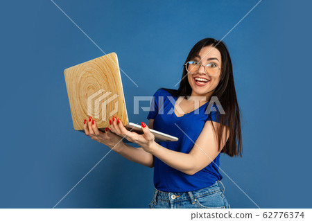 Caucasian woman's portrait isolated on blue studio background Caucasian woman's portrait isolated on blue studio background 62776374