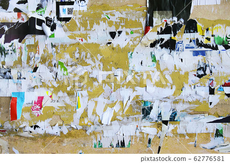 Dirty street yellow wall with old torn and peeling 62776581