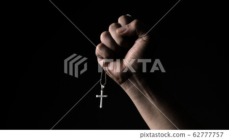 Silver crucifix or cross pendant and necklace on body or hand studio shot black color background which represent to praying for god or jesus for christian religion people who have faith Silver crucifix or cross pendant and necklace on body or hand studio shot black color background which represent to praying for god or jesus for christian religion people who have faith 62777757