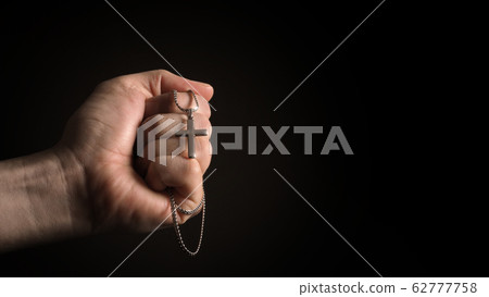 Silver crucifix or cross pendant and necklace on body or hand studio shot black color background which represent to praying for god or jesus for christian religion people who have faith Silver crucifix or cross pendant and necklace on body or hand studio shot black color background which represent to praying for god or jesus for christian religion people who have faith 62777758
