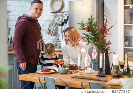 Parents with son in kitchen during Christmas Parents with son in kitchen during Christmas 62777827
