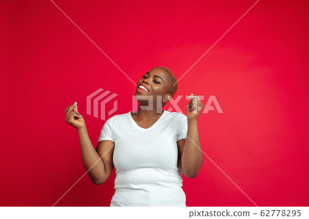 African-american young woman's portrait on red background 62778295