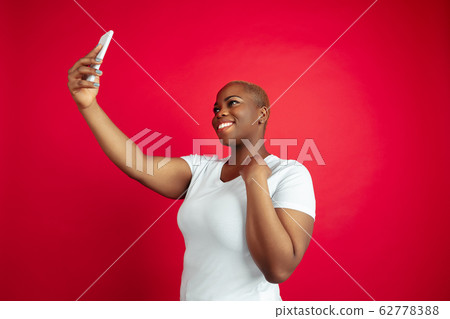 African-american young woman's portrait on red background 62778388