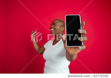 African-american young woman's portrait on red background 62778390