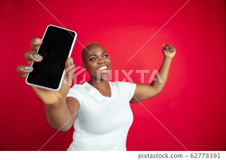 African-american young woman's portrait on red background 62778391