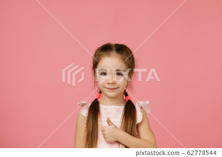 little child girl in dress showing thumbs up 62778544