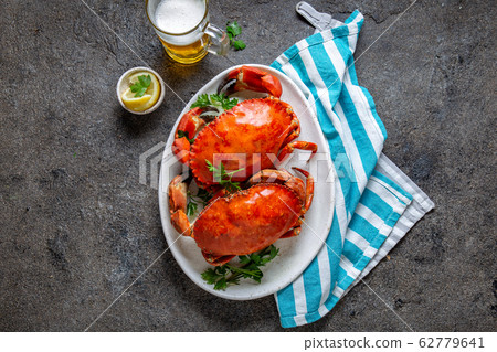 Whole cooked crabs on white plate with lemon and Whole cooked crabs on white plate with lemon and 62779641