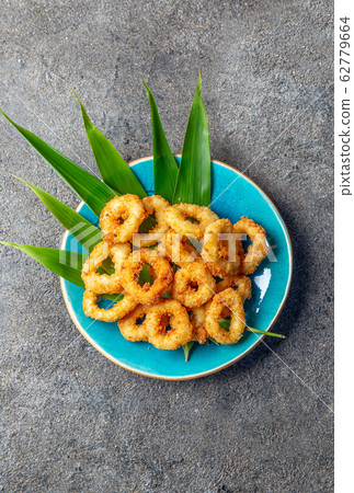 Fried squid rings on blue plate decorated with Fried squid rings on blue plate decorated with 62779664