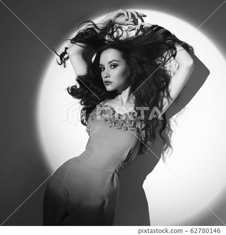 Beautiful brunette woman in beam of searchlight Beautiful brunette woman in beam of searchlight 62780146