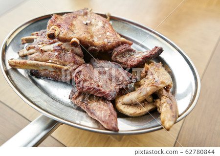 Various grilled meat set heated on coals. Barbecue restaurant menu. Many different food on the table. Dinner party or Banquet Various grilled meat set heated on coals. Barbecue restaurant menu. Many different food on the table. Dinner party or Banquet 62780844