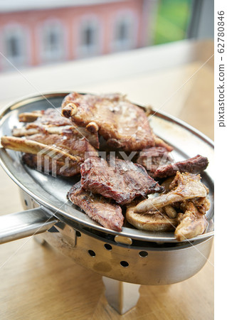 Various grilled meat set heated on coals. Barbecue restaurant menu. Many different food on the table. Dinner party or Banquet Various grilled meat set heated on coals. Barbecue restaurant menu. Many different food on the table. Dinner party or Banquet 62780846