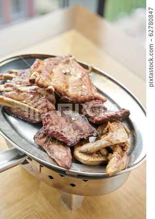 Various grilled meat set heated on coals. Barbecue restaurant menu. Many different food on the table. Dinner party or Banquet Various grilled meat set heated on coals. Barbecue restaurant menu. Many different food on the table. Dinner party or Banquet 62780847