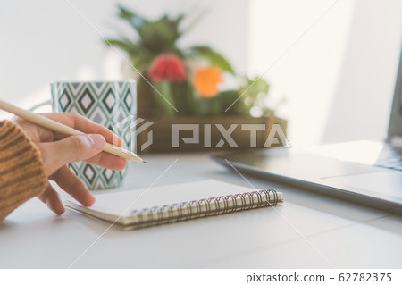 Woman hand write down in white memo notebook for Woman hand write down in white memo notebook for 62782375