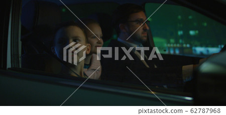 Girl watching and waving from car window 62787968