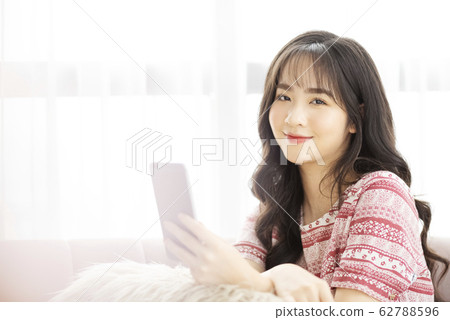 A young lady with a smartphone on the sofa 62788596
