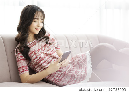 A young lady with a smartphone on the sofa 62788603