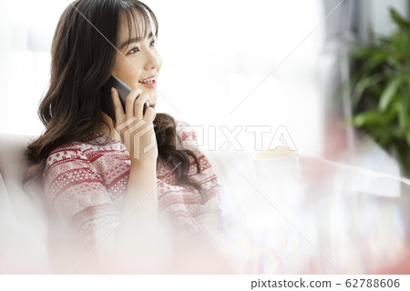 A young lady with a smartphone on the sofa 62788606
