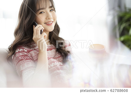 A young lady with a smartphone on the sofa 62788608