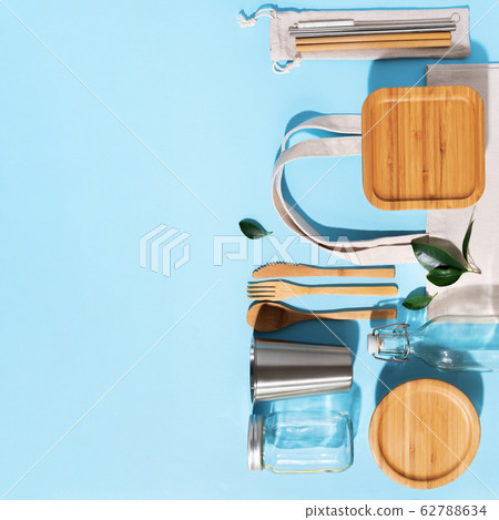Sustainable lifestyle. Zero waste, plastic free shopping concept. Cotton bags, glass jar, bottle, metal cup, straws for drinking, bamboo cutlery and boxes on blue background 62788634