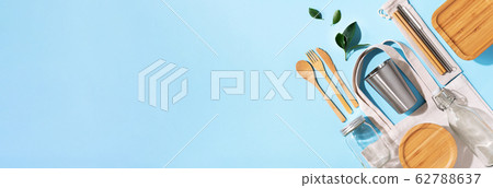 Sustainable lifestyle. Zero waste, plastic free shopping concept. Cotton bags, glass jar, bottle, metal cup, straws for drinking, bamboo cutlery and boxes on blue background. Banner Sustainable lifestyle. Zero waste, plastic free shopping concept. Cotton bags, glass jar, bottle, metal cup, straws for drinking, bamboo cutlery and boxes on blue background. Banner 62788637