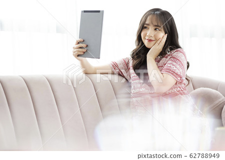 A young lady with a smartphone on the sofa 62788949