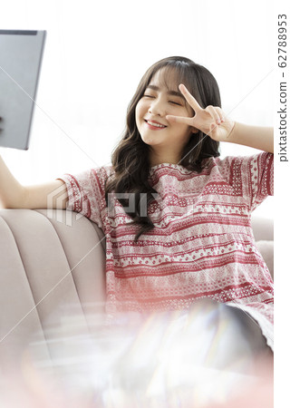A young lady with a smartphone on the sofa 62788953