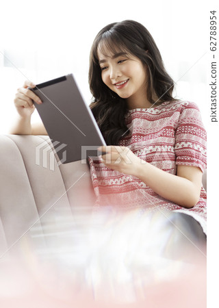 A young lady with a smartphone on the sofa 62788954
